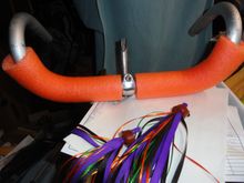 This is foam covering from a pool noodle that took some effort to move up the bars.  I didn't use soap and water like was advised for the foam tape of yesteryear.  The levers come on board next and the special leather black covers for the levers should cover the theme for the bar set up.   Note that the special four color streamers for the bars are ready for install when levers and lower foam is installed.  