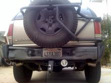 spintech dual exhaust custom built by me with double wall stainless steel tips. custom bike rack mounted to rear spare tire mount and rear spare tire moved down 3 inches for better view out of the back window. 4.5 inch round fog light mounted below bumper for better view while reversing in the dark.... custom dent on drivers side bumper!