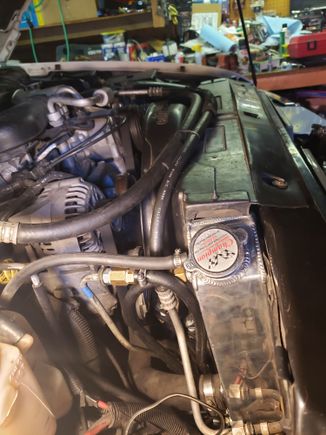 View from pass. side showing side of radiator and routing of transmission cooling hoses. Taking out the battery and the battery tray helps a lot.