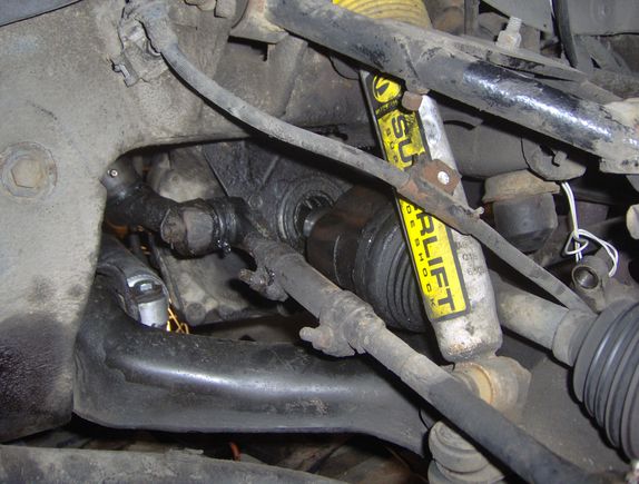 Drive axle partially removed before I realized I would have to also remove the steering knuckle to get it out.