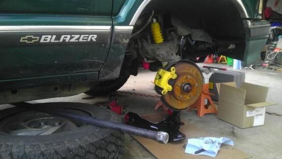 Replacing lower control arm bushings.

Lower arm on the ground has new red polyurethane bushings, painted with Eastwood Extreme Chassis Black.
Upper arm gets replaced later with 2" Lift Kit.
Frame was painted to test the paint.
Wheel well done with Dupli-Color Pro Undercoat.
Rotor rusted when it rained in the middle of all this :)