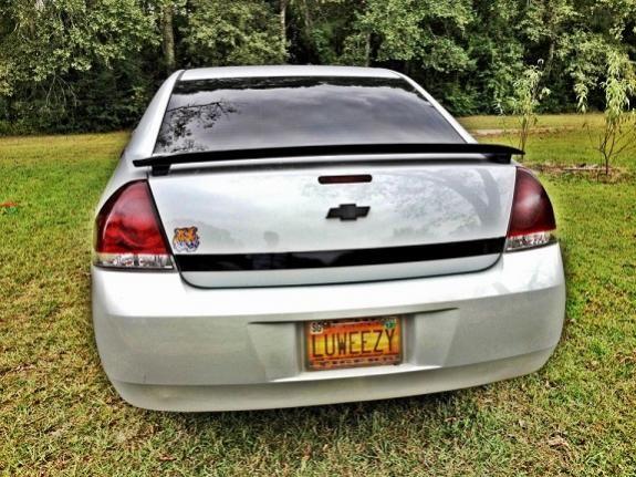 The Back (HD effect)

2% Tint 
-installer said it was 5, a cop's gun read 2% lol

Black Chevy Bowtie
-looks better than the stock gold and fits my black on white scheme

Added Black Spoiler 
-my LT did not come with one and got it painted black to match my scheme instead of white

Black Trunk Strip 
-complements the black spoiler plus there is nothing chrome on this car (never seen this done, so i'm proud of it)

Tinted Tail Lights 
-stock impala lights are too bright red and it goes with the scheme

Painted Black Impala Logos 
-2010s don't come with them so I got my own, scratched off the chrome finish and coated them black

Debadged Trunk 
-Took off the Dealership logos, Impala LT letters, and Flex Fuel Emblems for a cleaner look

LSU Tiger Head
-Reppin my team in the best conference in football.  The SEC!!! Bama jammas and Gator Haters welcome =)

Custom License Plate - LUWEEZY
-My state custom spelled, acquired nickname for me and/or my car.  I love where I'm from and you may not understand it.  To be politically correct, if you were asked to spell Louisiana the way it actually sounds, this is what it would look like - LUWEEZYANA.  Hate it, love it, all of the above it.  I don't care either way
