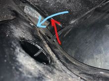 The blue arrow is the top of the frame.  There are three holes.  Does the parking brake cable route thru the roughly 1" diameter round hole shown with the blue arrow.   The red arrow I believe is where the parking brake cable routes through the fire wall.