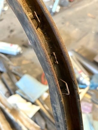 The rear bow had staples driven into the metal to secure the tacking material.  The staples were mostly rusted away at the ends of the bow.
