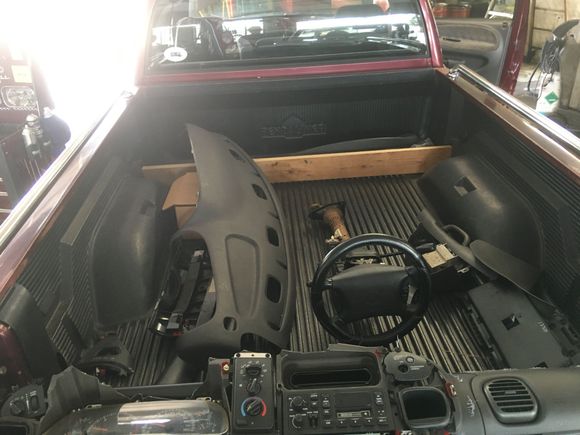 Parts piled in bed, along with new dash pad.