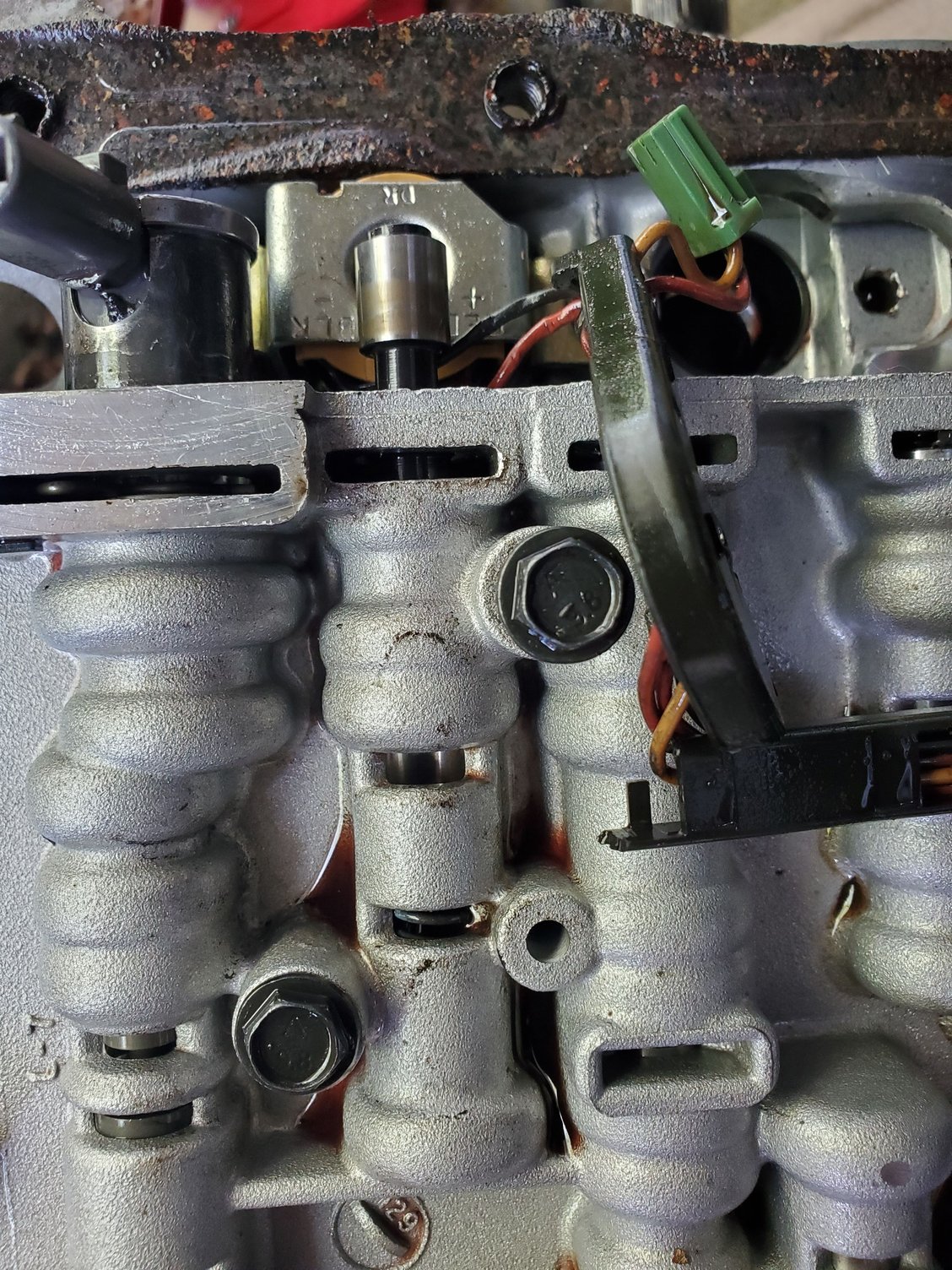 With the hemostats between the strait ears spread till no longer in end plug groove and spring pushes valve and plug outward. This is not as easy to keep tension on this while spreading but stay with it. (Some have used cheap needle nose pliers and filed or ground till thin enough to fit clip hole). After the plug pops out or is assisted remove valve and spring.