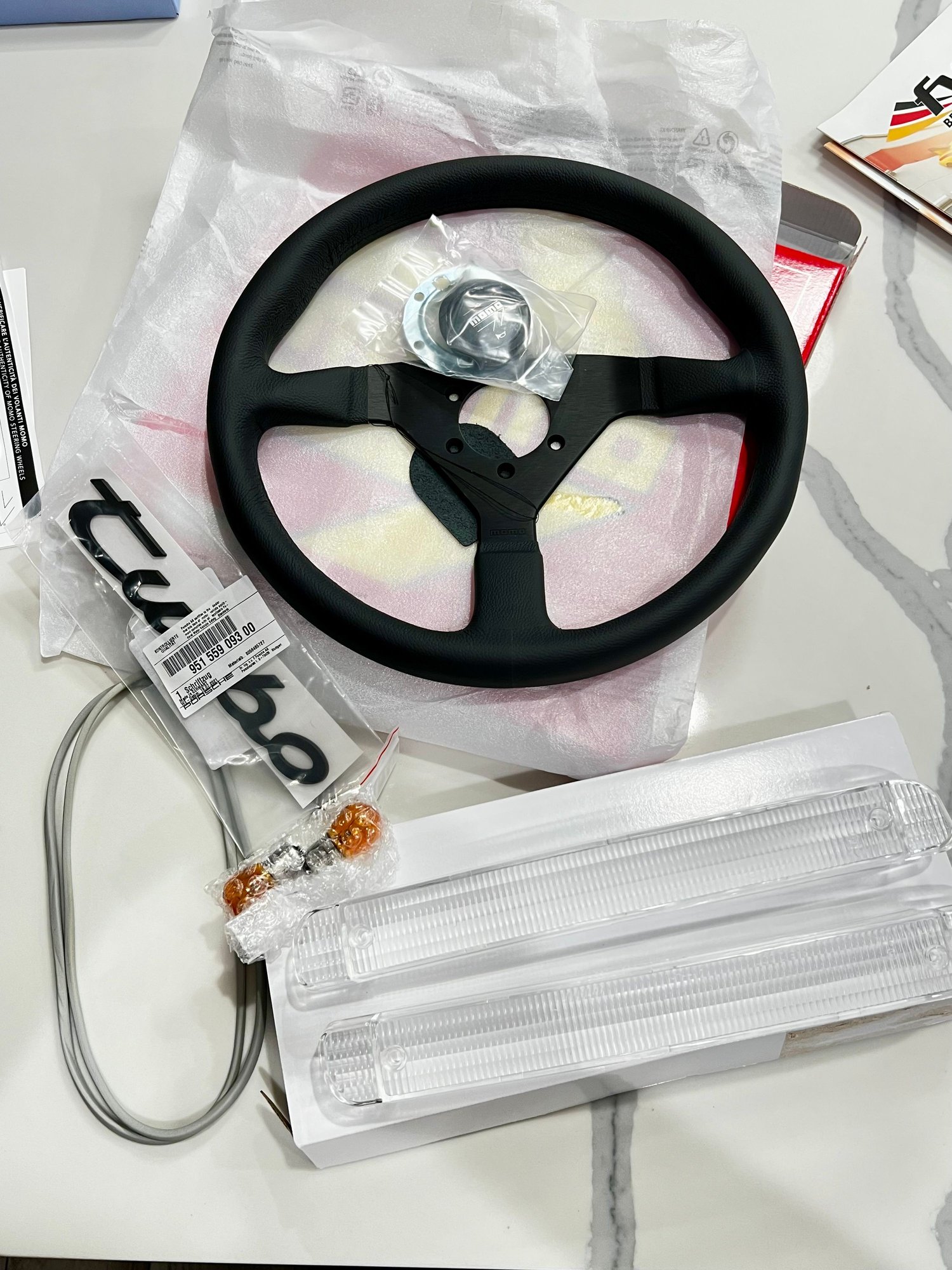 Momo Monte Carlo 350mm leather steering wheel, OEM clear front turn signals, and the correct Turbo badge for the rear. 