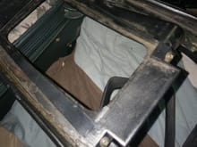 You can see the two screws holding it to the underside of the console frame, and the "wing" extending to the area under where the ash tray will be. There is a similar "wing" that extends under the opening for the window switches.