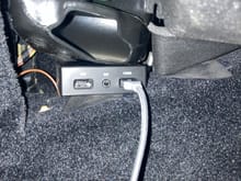 USB/AUX box sandwiched under the passenger floor vent and the tunnel