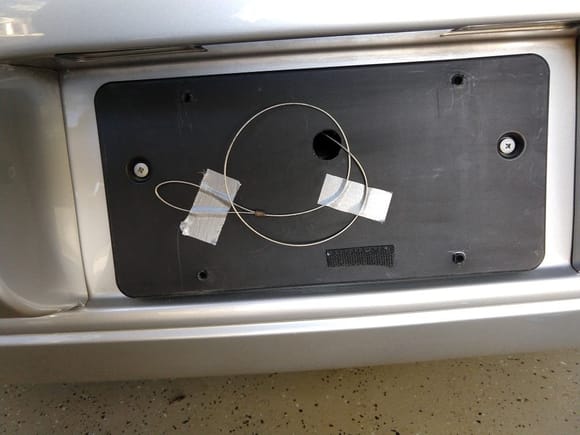 drilled 3/4" hole in license plate mount to allow the cable to be secured on the surface with duct tape  