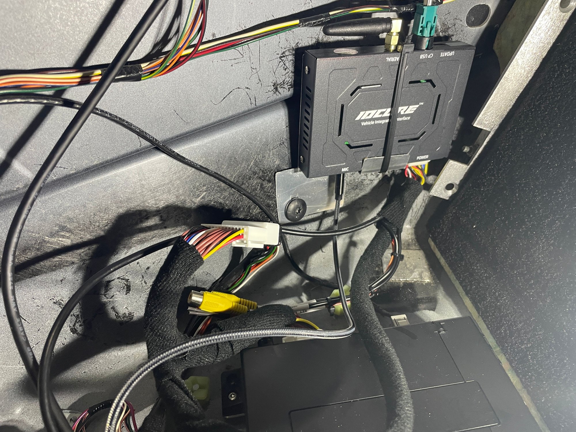 Improvised bracket using existing bolt to secure unit behind carpet.