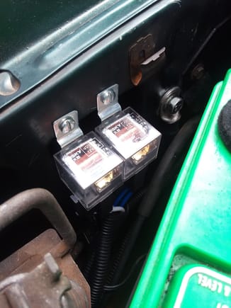 Headlight harness relays mounted on passenger fender behind the battery.