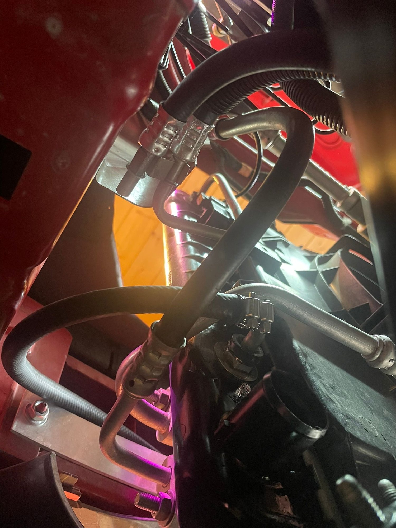 The modified cooler assembly in place. One hose is connected, the upper one isnt. Note the 2 clamps. The A/C pipe leaves little clearance! Have the Jesus clips in place before installing the lines into the transmission. Then push into place, slide the dust guard over the connections.