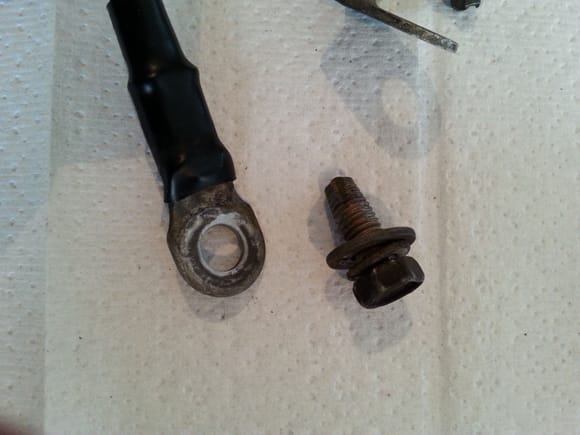 This image depicts secondary cable ground lug and thread cutting bolt  which connects to body/frame. Both fastener and lug exhibit corrosion. Not bad for 17 years, but time to replace.