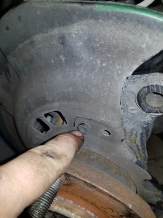 Undo these 4 bolts holding the dust guard in place with a wrench.  Don't try to use a socket, because you cant fit the ratchet in between the bolt head and the back of the hub.