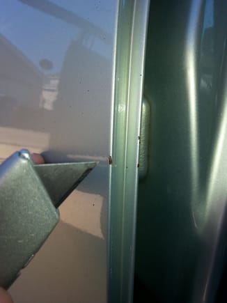 Used box cutter to scrape away rust within the nick.. Worked well, and without disturbing  the perimeter. Used magnifying visor to better view the work area.