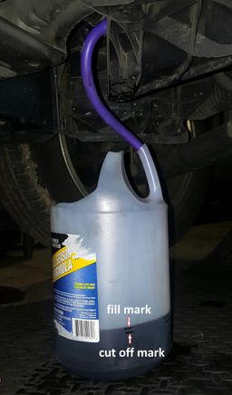 Any clear container with handles you can cut as shown, then your 3/8" or so drain hose can slip right down the handle to hold it steady in place. *Note i have 2 marks on the container. One you crank the engine for 5 seconds, when shutoff the fluid continues to flow for a good second. So i used an inspection mirror to observe the container when the fluid hit the cut-off mark for me to shut the engine down.