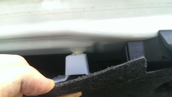 There are 2 white (1 on each side of latch assembly) that are holding the trim panel on to trunk lid just below the license plate position.