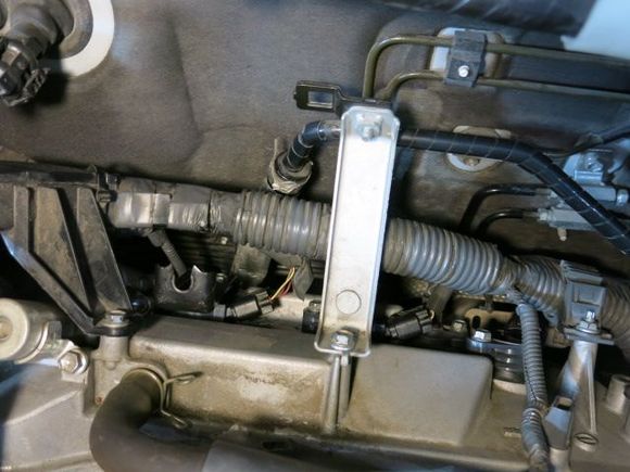 Photo just before re-installing my intake pentium.  Note the slotted bracket which allowed me to partially install the PITA bolt.  I also realized that the UK mechanics must have removed all of the fasteners to that middle silver bracket to to the spark plug installation without removing the intake.  However access is still tight and I do not recommend this until you have the skill.  After I removed the PITA bolt, it only took me about 20 to 30 minutes to remove the intake.