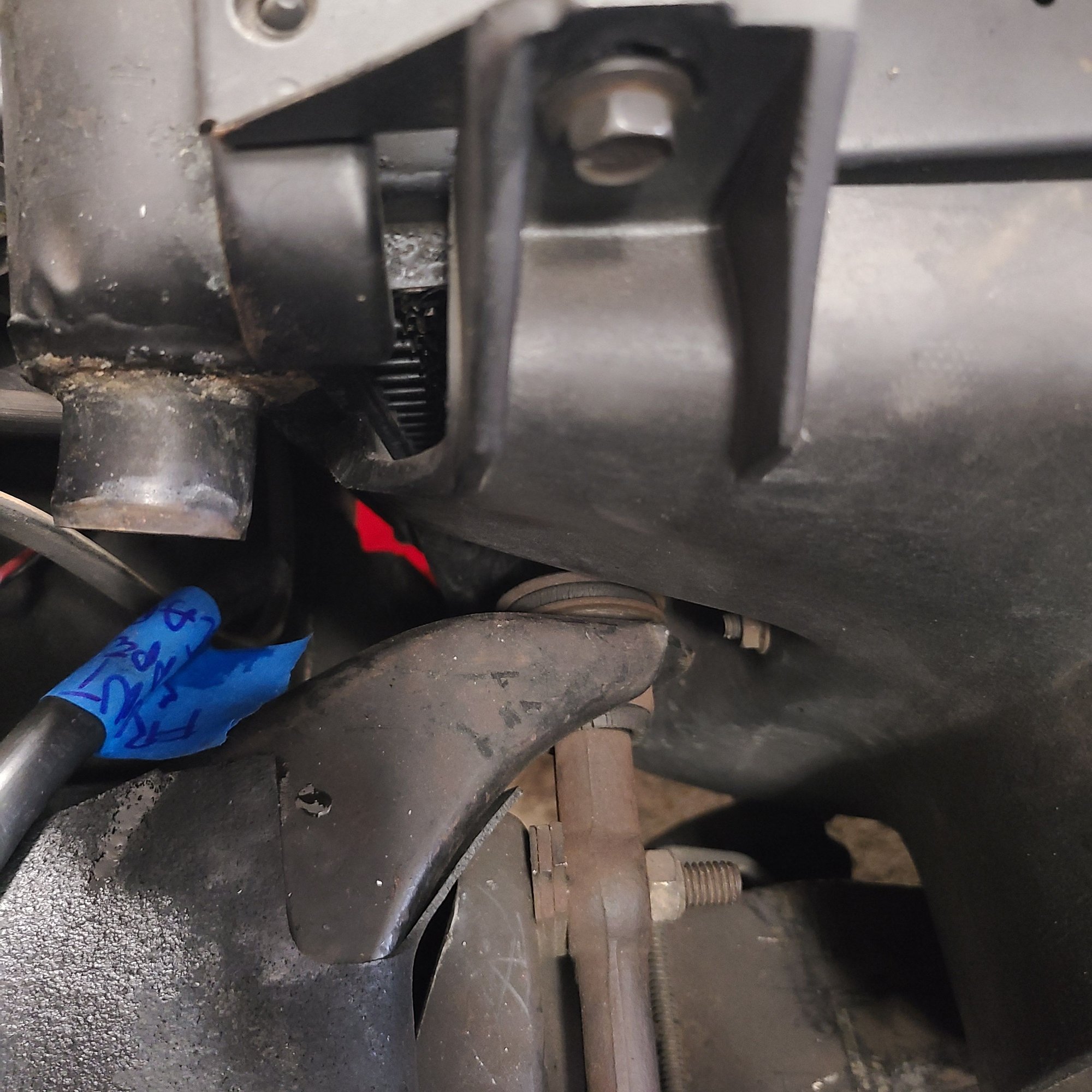 This is a major problem in getting the shroud out.  The upper drivers side A frame shaft and bushing is in the way.  You need to push the radiator shroud and support forward to get clearance. 
