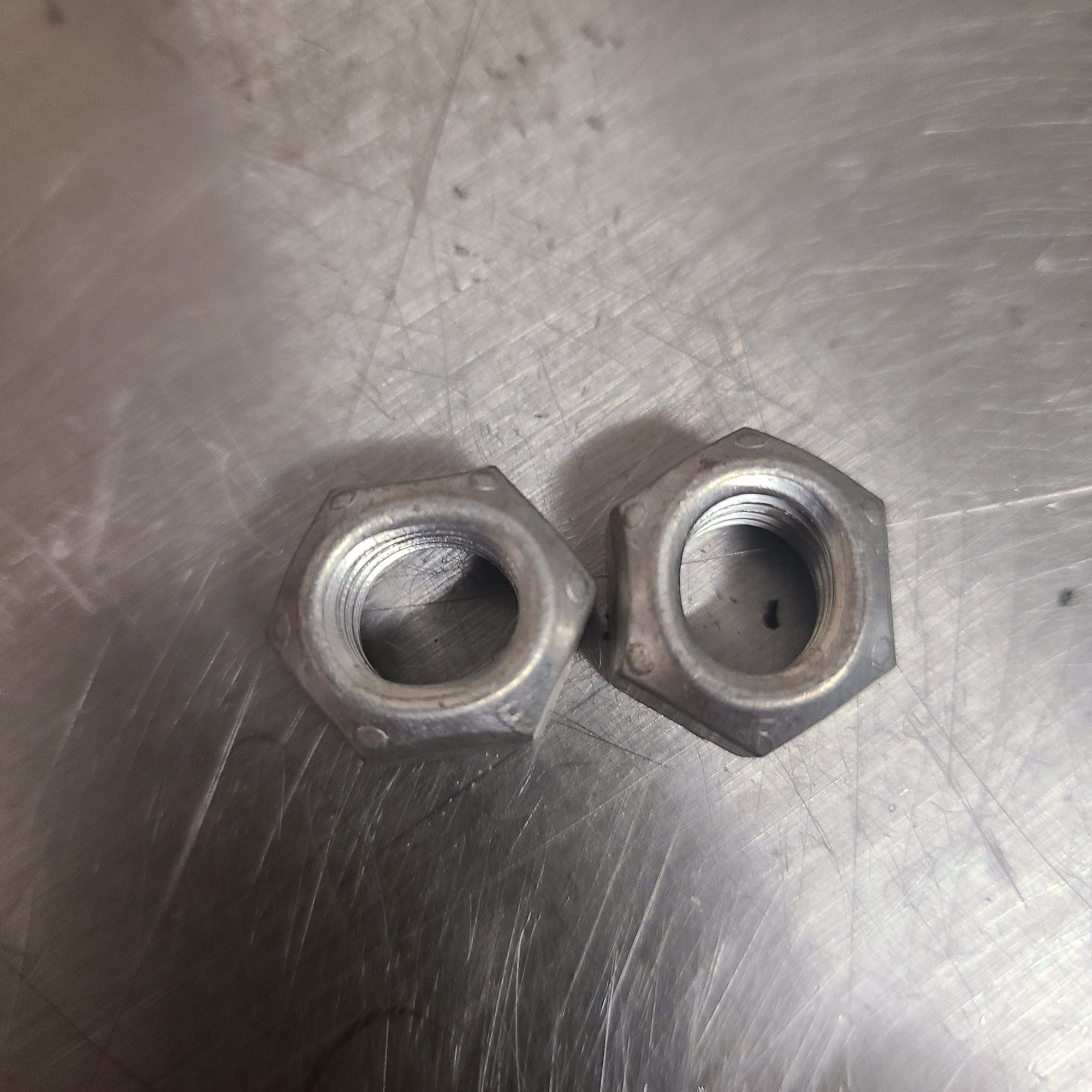 Prevailing torque nuts for exhaust manifolds.  They are deformed to stay tight under high thermal expansion.