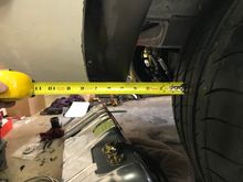 There is about 4 1/2” between the tire and the rear wheel well edge. At ride height the wheel actually only moves back 1/2” which results in 4”. 