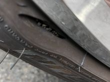 Came out to my car two days ago and noticed this.  The side wall of my 2 month old front left tire appears to be damaged with a bulge forming.  It's very close to where the tire and rim meet. No rim damage.  I ordered a new tire.  My question is...does this appear to be the result of hitting something sharp while driving, maybe even a pothole or railroad tracks or a manufacturer defect and am I taking a risk driving the car?  Tire pressure has not moved since I've noticed it.