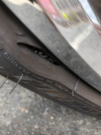 Came out to my car two days ago and noticed this.  The side wall of my 2 month old front left tire appears to be damaged with a bulge forming.  It's very close to where the tire and rim meet. No rim damage.  I ordered a new tire.  My question is...does this appear to be the result of hitting something sharp while driving, maybe even a pothole or railroad tracks or a manufacturer defect and am I taking a risk driving the car?  Tire pressure has not moved since I've noticed it.