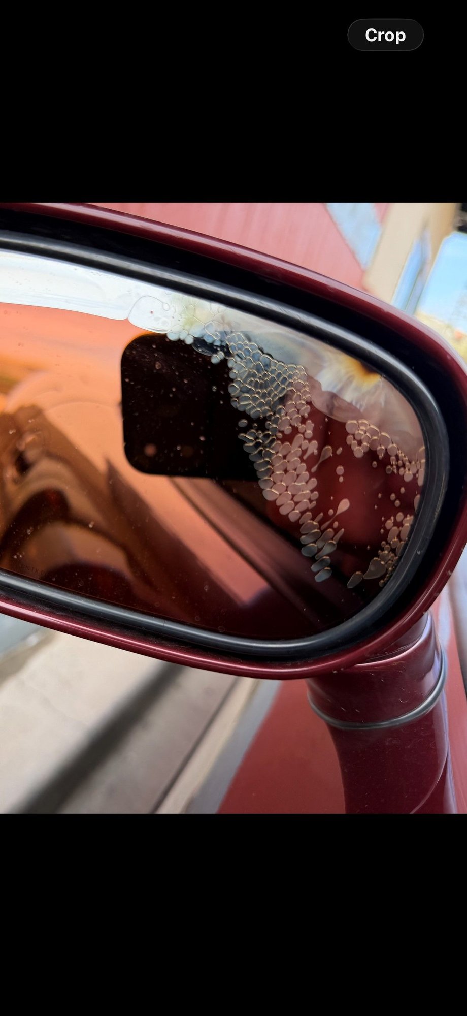 Water got behind the glass of the mirror, plus a burnt or rusty spot top right??