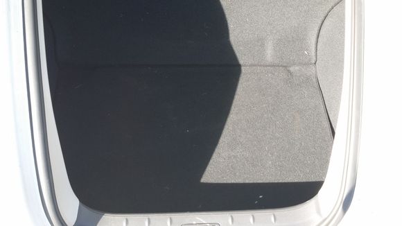 Trunk floor laying over the tire in the back