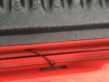 Wire going through tailgate into bed. The disconnect is a few inches inside/under the bed