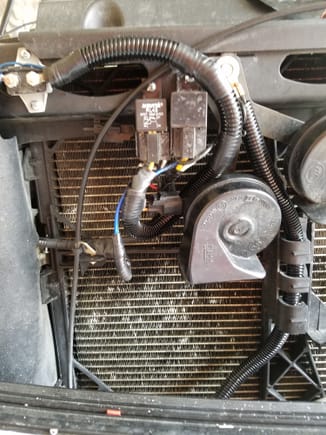 Notice to the left the thing with 2 screws in grey part holding it to radiator core support and tow nuts with wire connectors on it. That WAS my breaker.  Yeah don't put that there or anything for that matter. Hood will smash it.
