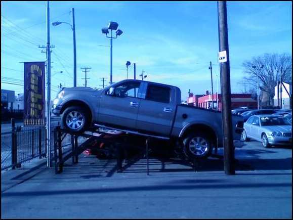 F150 up on the lift at the dealership.  The previous owner added some lincoln navigator wheels on the truck.  Not a bad look but 20" Eagle Alloys soon to come with 35" tires
