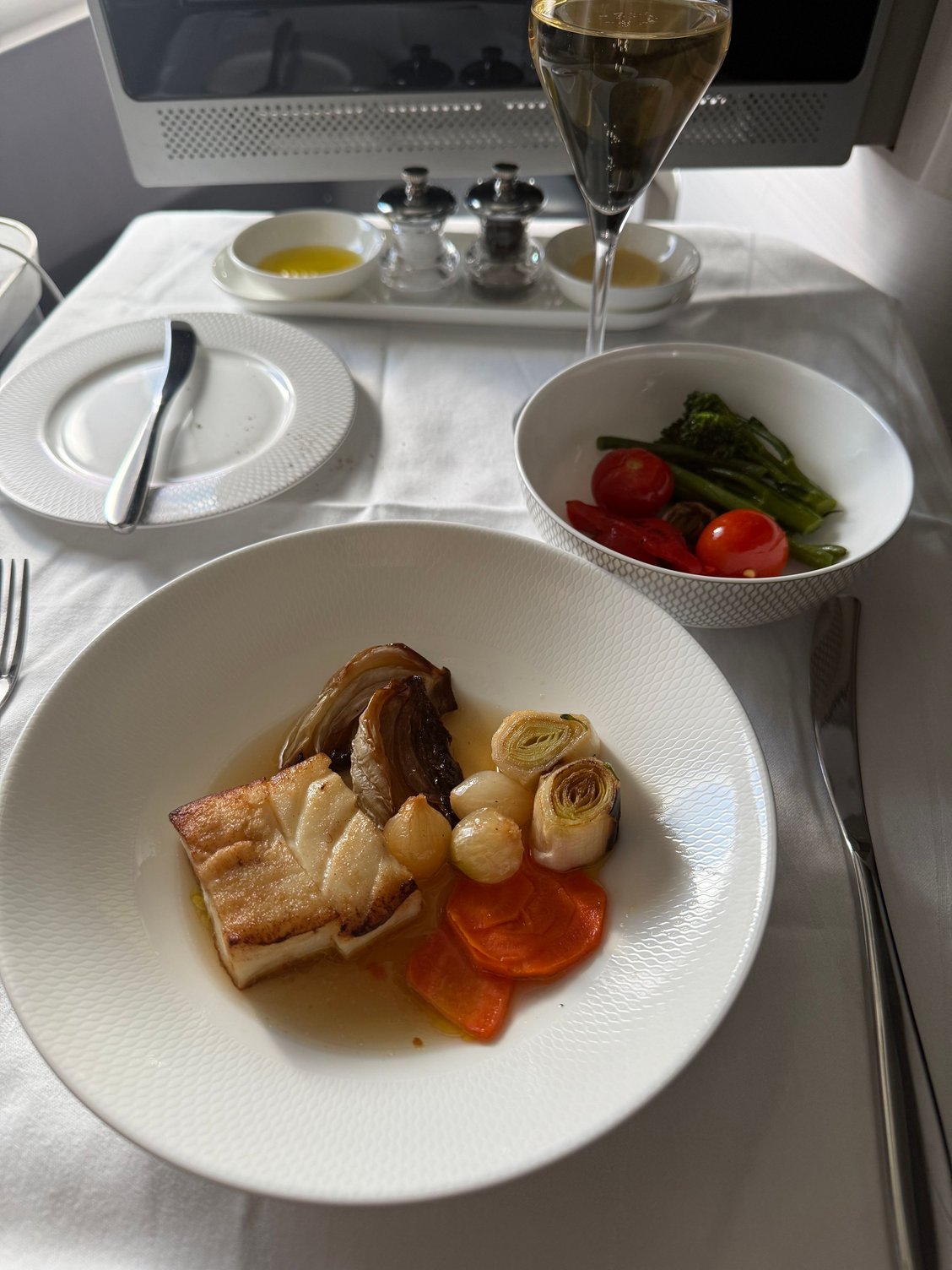 Halibut with invariably u seasonal vegetable side. Fish predictably overcooked and smoked fish consomm� fairly tasteless comes with braised baby fennel (nice), leeks (very nice) and pearl onions (vinegary. Why???side veg (cherry tomatoes, vinegary res peppers and tasteless broccolini) should be served in July, not February. 