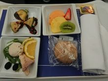 Before landing: Smoked trout served with arugula and olives. Zucchini roll stuffed with blue cheese served with balsamic sauce. Fruit salad.