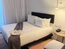 A beach bag with a thin towel and a notebook were on the bed as gifts. There are power outlets and USB-A ports at the bed.