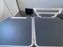 Nifty fold-out phone/tablet stand.  Reversible as well so available for half and full tray table deployment 