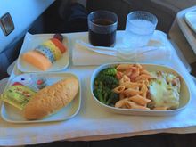 Pre-arrival meal chicken breast with pasta and broccoli, dessert fresh fruit