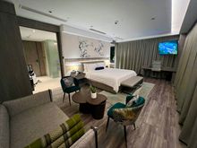 Bedroom with seating area, and desk (out of shot)