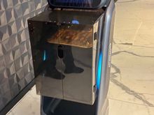 A robot brings food out from the kitchen 