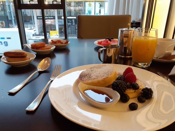 The pancakes and some side dishes ( small selection of fruit  at end of table from self service section)