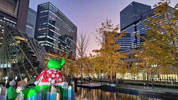 North exit of Osaka station. The bear has its christmas cape on. The Waldorf Astoria is the tall building to the right with the Canopy hotel behind me close by. The trees have  lights attached on them and were switched on at 1700