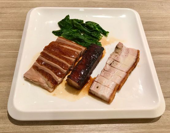 Trio of roast duck breast , char siew and siew yoke with kai lan