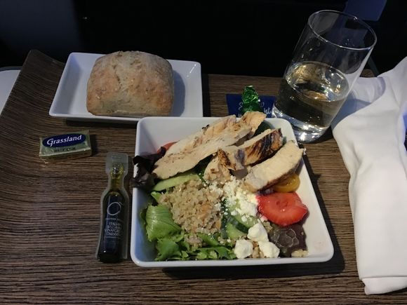 Described as chicken salad.  Was quinoa with grilled chicken slices on top of Greens withCherry tomatoes, slices of cucumber and feta crumbles. Strawberry half . Balsamic vinegrette on side. Warm multigrain roll with butter. Chocolate.   Very good , enjoyed that it was heavy on protein .