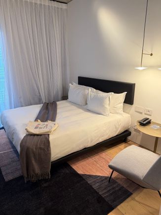 A beach bag with a thin towel and a notebook were on the bed as gifts. There are power outlets and USB-A ports at the bed.