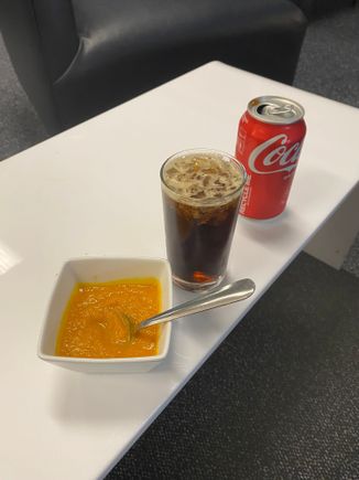 Rum-and-Coke in the middle and a carrot soup to the left 