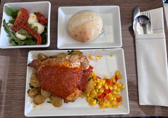 I preordered the Piri Piri Chicken. It was a boneless, skin on breast. It was described as spicy, but it was pretty mild. The corn was excellent. The potatoes were good. The salad, with pesto and fresh mozzarella and tomatoes was the highlight of the meal. I wish that could have been the main dish. It was excellent. The bread was soft and tender. 