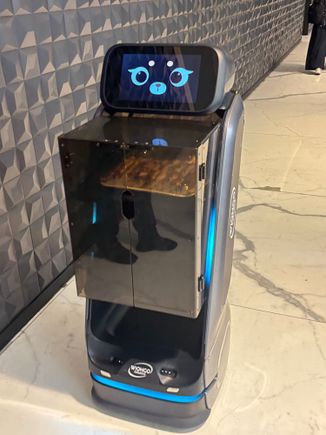 A robot brings food out from the kitchen 