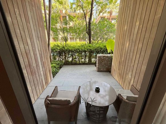 Living Room Patio.  You can just make out the central courtyard pool through the shrubs.  There's a stairway to the right that leads down to a gate to access the pool
