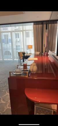 The table that contains the mini bar, dresser, and many charging ports